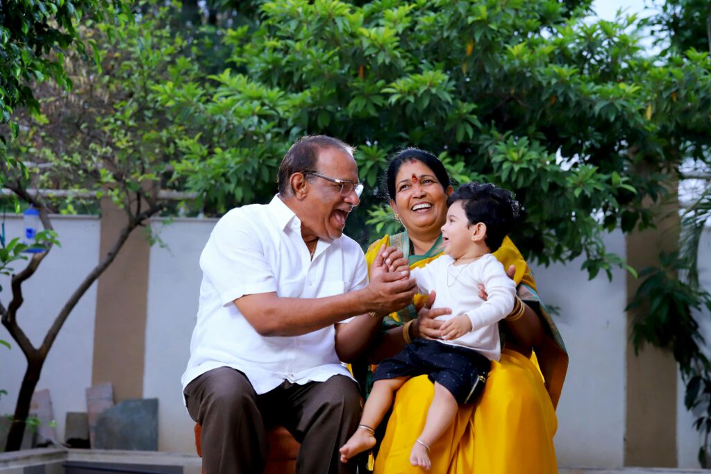 Three-generation family enjoying time outdoors in a lush Indian garden.
