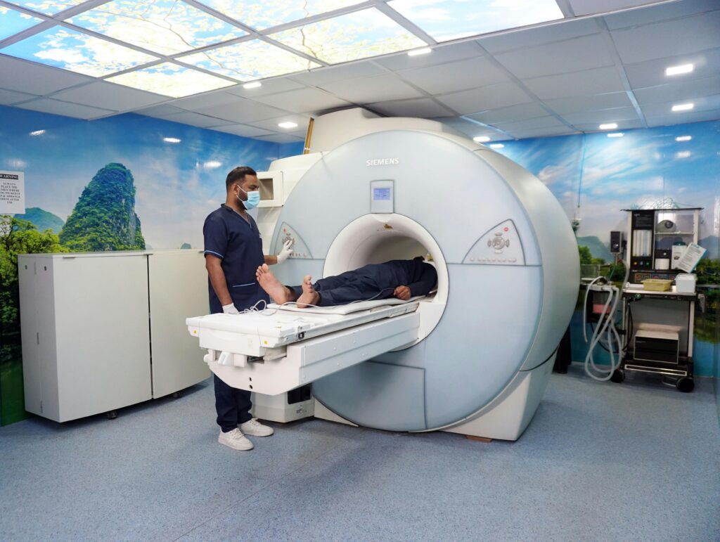 A medical technician assists a patient in an MRI machine in a healthcare facility, showcasing modern medical technology.